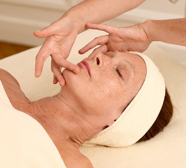 Praticienne sculptant les contours du menton et des joues lors d'un massage facial sur mesure Méthode LB Facialistes